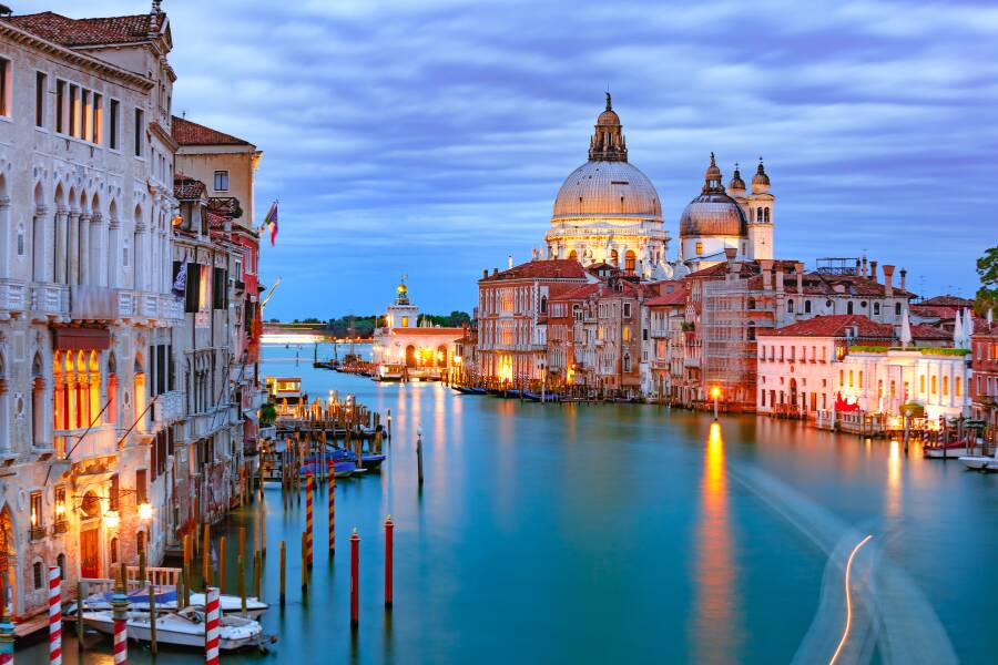 Le Grand Canal de Venise, illuminé à la tombée de la nuit, guide le regard vers la majestueuse basilique Santa Maria della Salute sous un ciel crépusculaire.