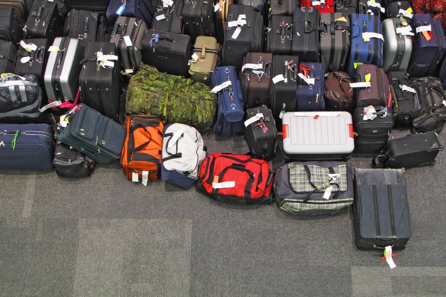 De nombreuses valises de différentes tailles, couleurs et formes sont regroupées dans une zone de récupération des bagages. Chaque bagage possède une étiquette facilitant son identification après le vol.