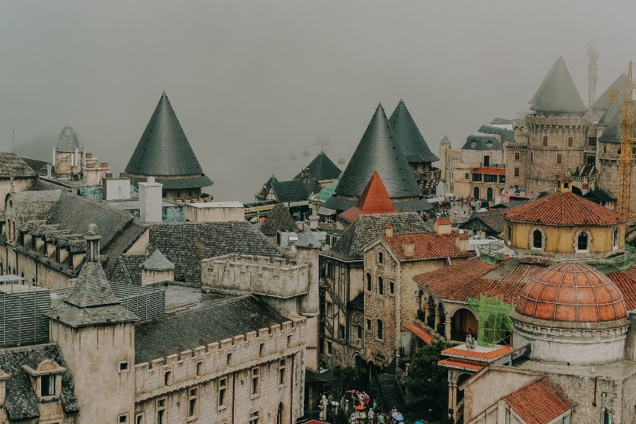 De vieilles bâtisses aux toits pointus et tours médiévales s'étendent sous une brume épaisse enveloppant la ville.